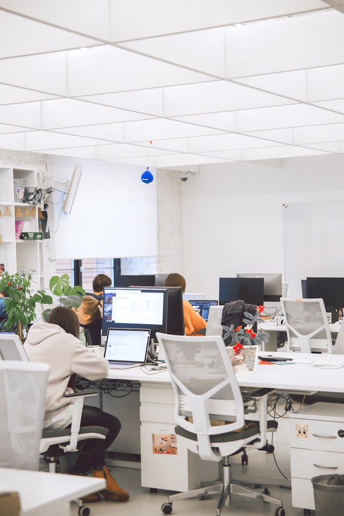 Bright modern office interior with employees working on computers. Ideal for business and productivity concepts.